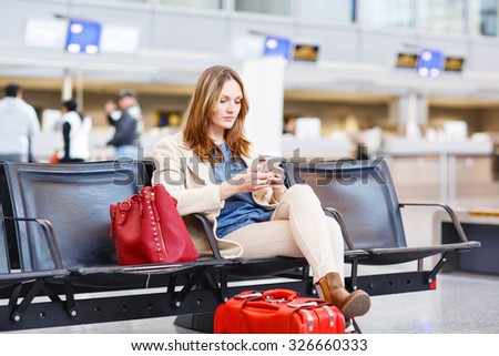 Young woman at international airport sitting waiting for cancelled or delayed flight. Female passenger at terminal, indoors.  Travel, business, people concept.