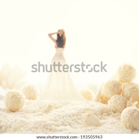 Woman in white dress in a fairy world of big candies. Unusual modern art