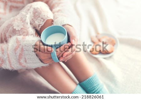 Soft photo of woman on the bed with cup of milk in hands top view point Soft photo of woman on the bed with cup of milk in hands top view point