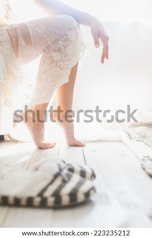 Soft photo of woman on the bed with sunlight from window in bright white room