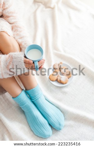 Soft photo of woman on the bed with cup of milk in hands, top view point
