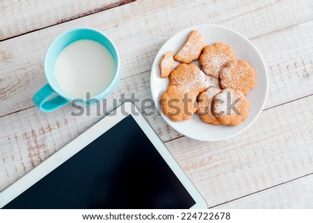 Cup of milk and cookies on a white wooden table. Top view