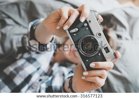 Soft photo of woman in checkered shirt taking a photo, top view point