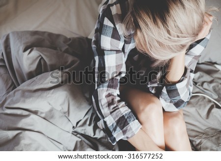 Soft photo of woman in checkered shirt on the bed, top view point
