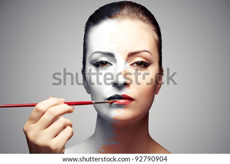 woman paints her  black and white face, bright makeup