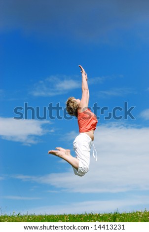 Happy jumping woman against the blue sky.
