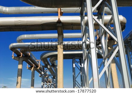 industrial pipelines on pipe-bridge against blue sky.