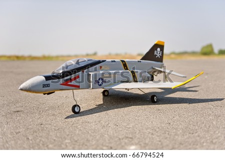 Homemade radio control toy aircraft with electric motor on runway.