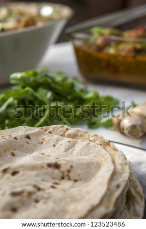 Indian naan bread with fresh coriander and ginger on table