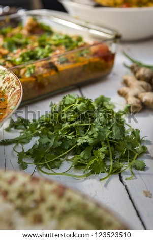 Fresh coriander on the table with typical indian food