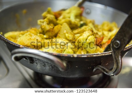 Cooking vegetarian, indian meal in metal crock