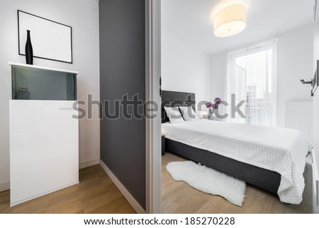 Stylish white bedroom in small apartment