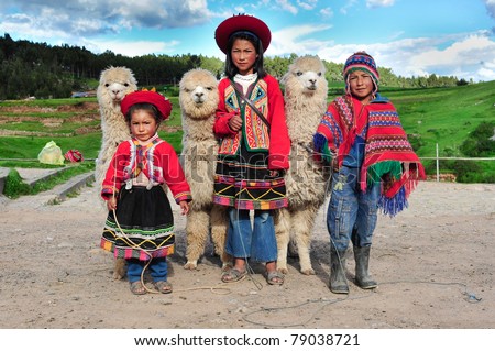 SACSAYHUAMAN, CUSCO, PERU - MARCH 08: Peruvian children in traditional dresses standing in row with small Alpacas on March 08, 2010 in Sacsayhuaman, cusco, peru.