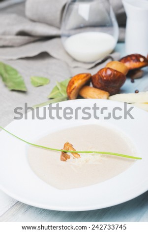 Mushroom cream soup with cheese and milk on the wooden table