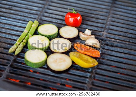 process of cooking vegetables on the grill - mix of tomatoes, asparagus, zucchini, bell peppers and mushrooms