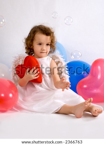 A little angel-girl embracing red heart, colour balloon around