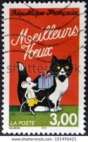 FRANCE - CIRCA 1997: A stamp printed in France shows mouse making him a gift to a cat, circa 1997
