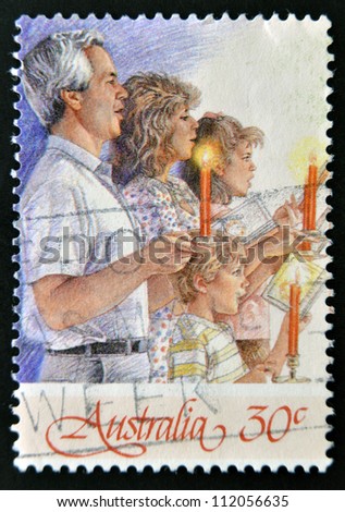 AUSTRALIA - CIRCA 1987: A Christmas stamp printed in Australia shows family singing with candles, circa 1987