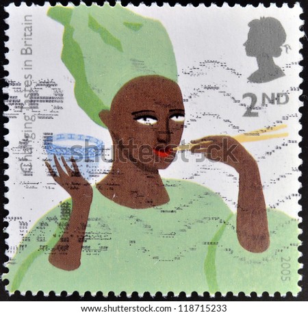 UNITED KINGDOM - CIRCA 2005: A stamp printed in Great Britain shos African Woman eating Rice, circa 2005