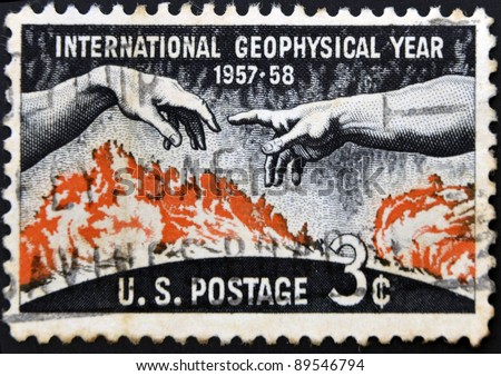 UNITED STATES OF AMERICA - CIRCA 1958: A stamp printed in the USA shows Solar disc and hands from Michelangelo?s Creation of Adam, International Geophysical year 1957-58, circa 1958