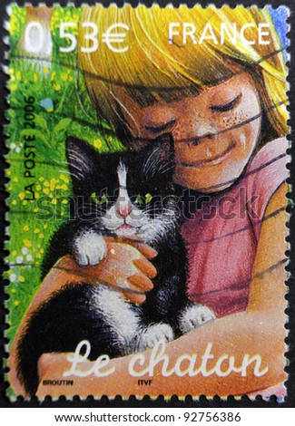 FRANCE - CIRCA 2006. A stamp printed in France shows a girl hugging a kitten, circa 2006