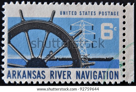UNITED STATES - CIRCA 1968: A stamp printed in USA dedicated to arkansas river navigation, shows ship wheel, power transmission tower and barge, circa 1968