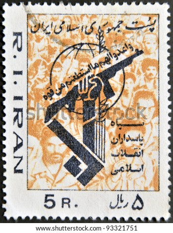 IRAN - CIRCA 1985: A stamp printed in Iran shows the drawing of a hand holding up a gun on a background of faces, circa 1985