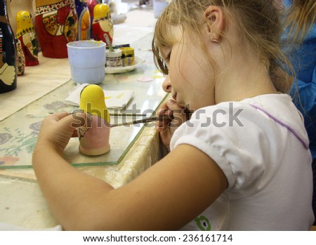 Little girl has a class of painting of matrioshka russian doll, Russia