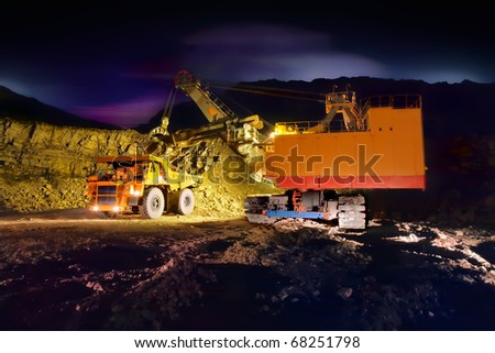 A picture of a big yellow mining truck at worksite (night)