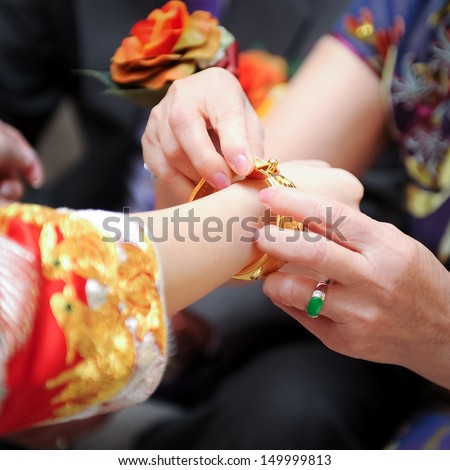 Elderly Relatives Presenting The Golden Bracelet As A Blessing In Chinese Wedding