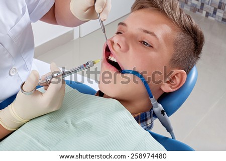 an injection of anesthesia to the patient before dental treatment