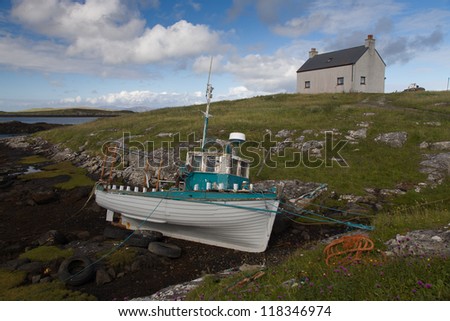 Old fishing boat on the rocks with the tide out on the Isle of Barra in the Outer Hebrides