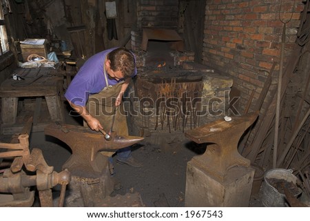 Blacksmith working with metal in old workshop