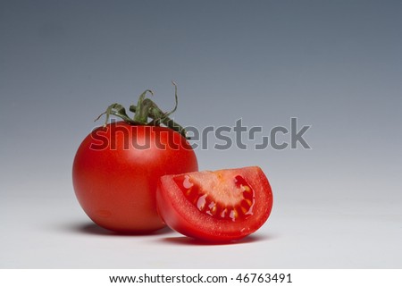 Tomato whole and sliced on a plain background