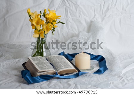Open Bible and flowers candle and ribbon