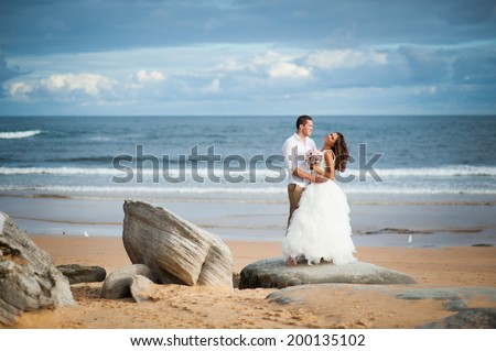 Gorgeous bride in a wedding dress and a handsome groom getting married at a beautiful beach