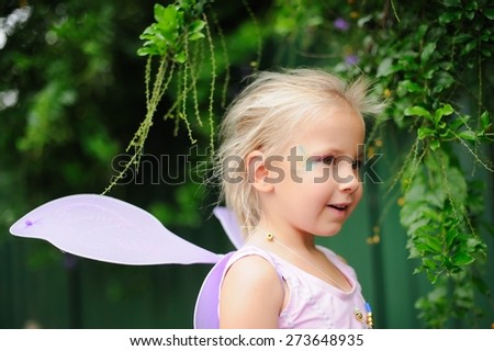 Portrait of a happy child, cute adorable little girl in a fairy costume with fairy wings on her birthday