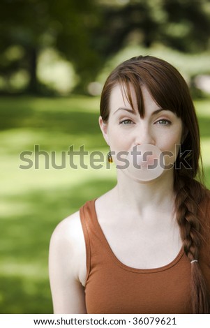 Portrait of a young woman blowing bubble gum