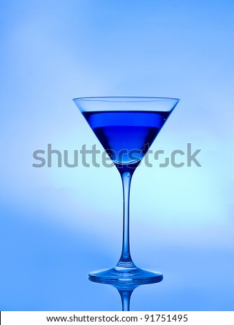 blue drink  on a blue background in a cocktail or martini glass