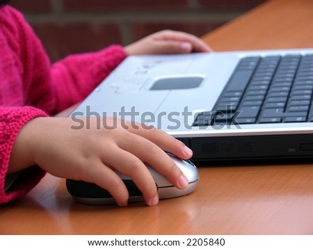 I can do it ! -- Close-up image of a little girl learning how to use computer to surf the Internet.