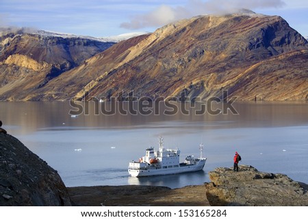 Adventure tourist and Russian Icebreaker at Blomsterbugten (Flower Bay) Franz Joseph Fjord in Eastern Greenland.