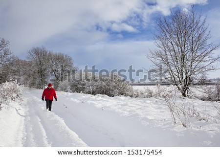 Walking in deep snow on a country lane in North Yorkshire in the northeast of England in the United Kingdom.