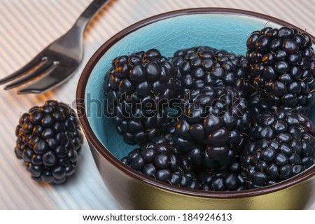 Blackberries are an edible soft fruit consisting of a cluster of soft purple-black drupelets.