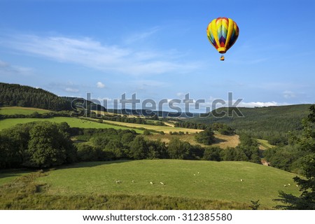 A hot air balloon flying over the countryside of the Yorkshire Dales in the north of England.