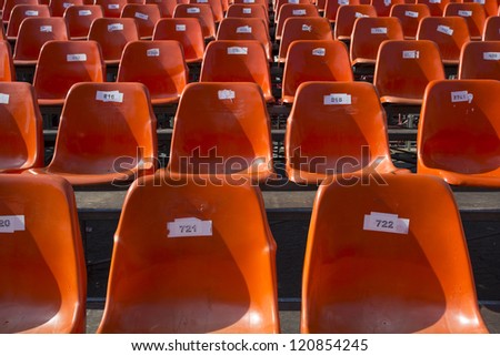 Lots of orange seats at an outdoor venue.