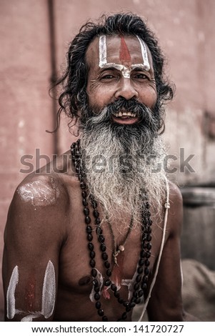 INDIA, VARANASI, JUNE 1: Portrait of an Holy Sadhu man with traditional painted face, praying near by the Gange in Varanasi, June 1, 2009, India