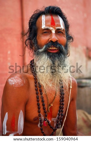 INDIA, VARANASI, JUNE 1: Portrait of an Holy Sadhu man with traditional painted face, praying near by the Gange in Varanasi, India. In Hinduism, sadhu is a term for a mystic, June 1, 2009, India