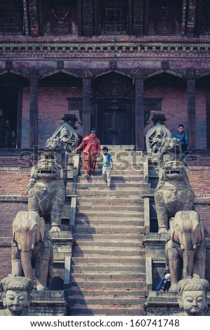 BHAKTAPUR, NEPAL, APRIL 24: Unidentified Woman and her child coming down the stairs of the Nyatapola temple in the old city of Bhaktapur. Nepal 2013.