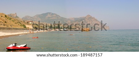 KOKTEBEL, UKRAINE, JULY 28: People swimming and sunbathing at the city beach of Koktebel in Crimea on July 28, 2004, Ukraine. The beach is one of the most popular holiday resorts in Crimea, Ukraine.
