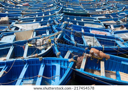 Group of blue fishing boats aligned in the harbour of Essaouira, Morocco